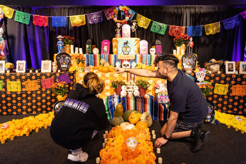 Students from the Hispanic Organization for Leadership and Achievement set up a Dia de Muertos altar in Scooters on October 31, 2022. Mark Brown/University of St. Thomas