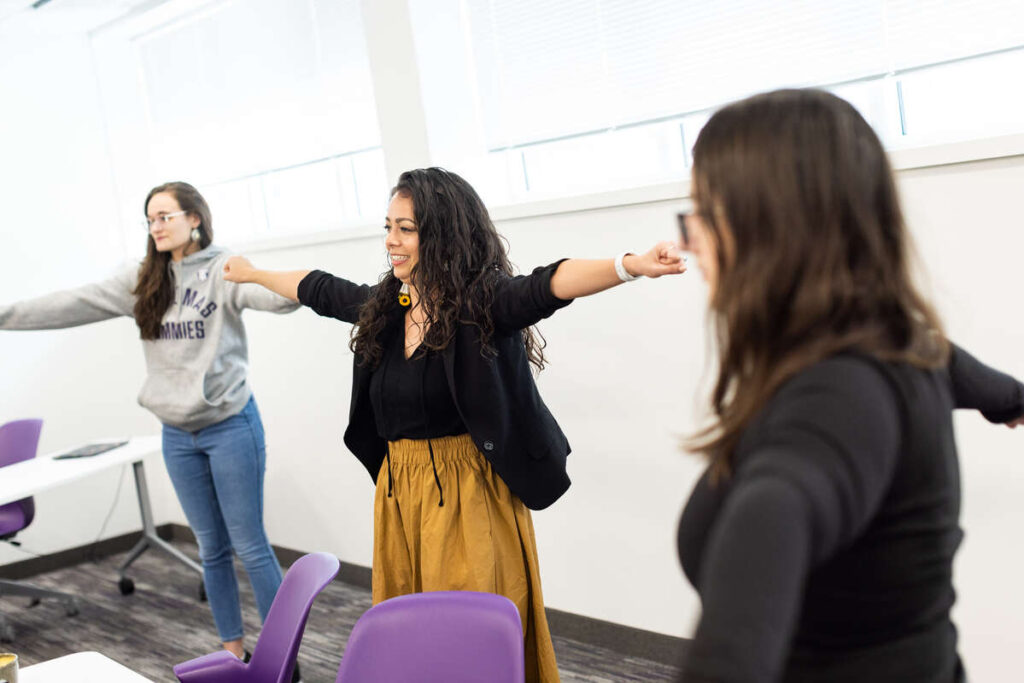 Social Work Professor Alicia Powers leads graduate students in stretches during a class session. Mark Brown/University of St. Thomas