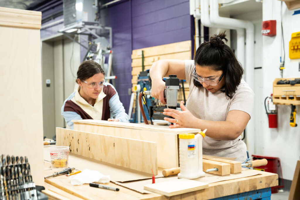 Students work with Engineering shop staff members on wood projects in the Engineering shop area in the Facilities and Design Center. Mark Brown/University of St. Thomas