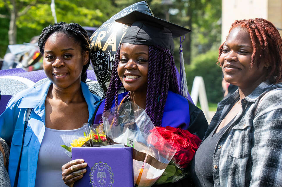 A student smiles with friends and family after the Dougherty Family College commencement ceremony on May 21, 2023, in St. Paul.