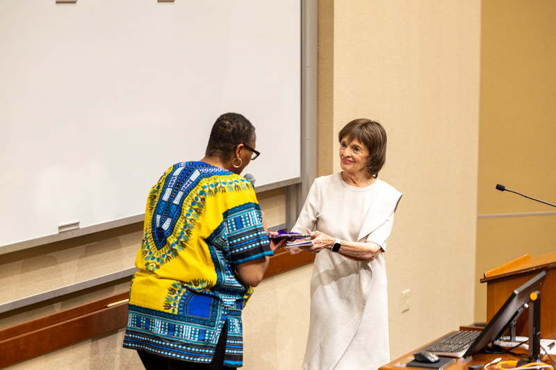 Dean Buffy Smith gives a gift to Marilyn Carlson Nelson 