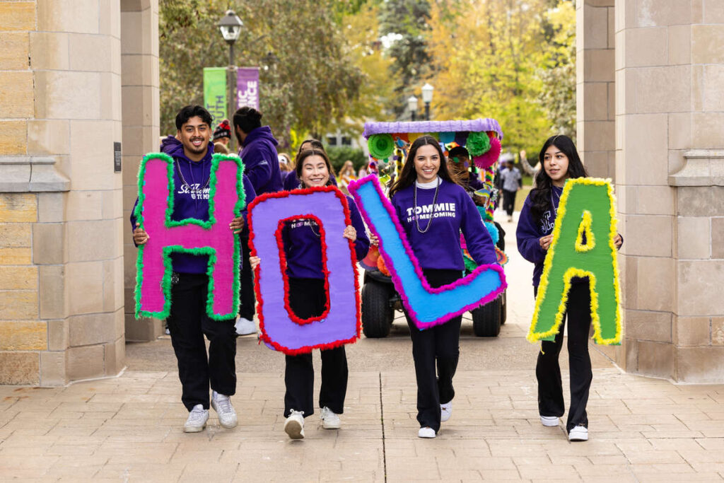Students walk with HOLA letters.