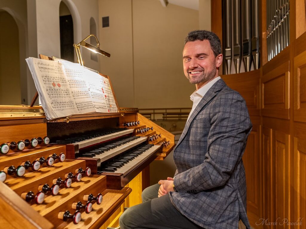 Dr. Jacob Benda sits at an organ for his concert in Poland.