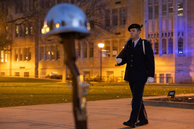 An ROTC member walks on the lower quad during a vigil.