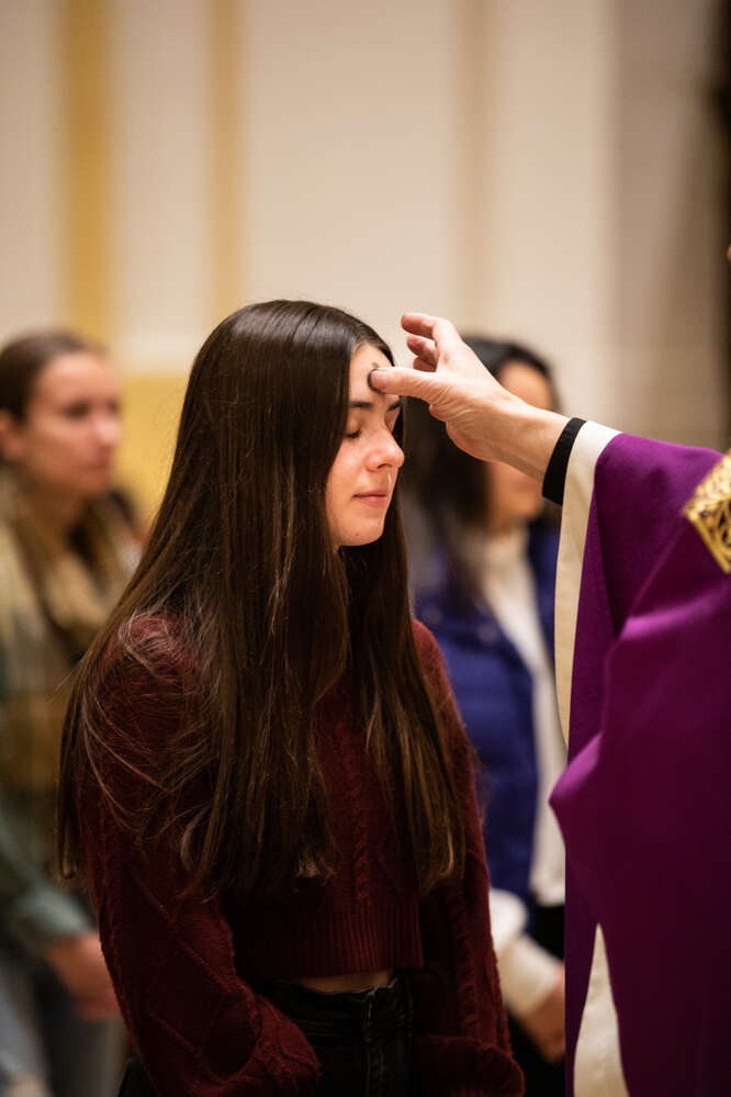 A parishioner is anointed during an Ash Wednesday mass in the Chapel of St. Thomas Aquinas on February 22, 2023, in St. Paul.