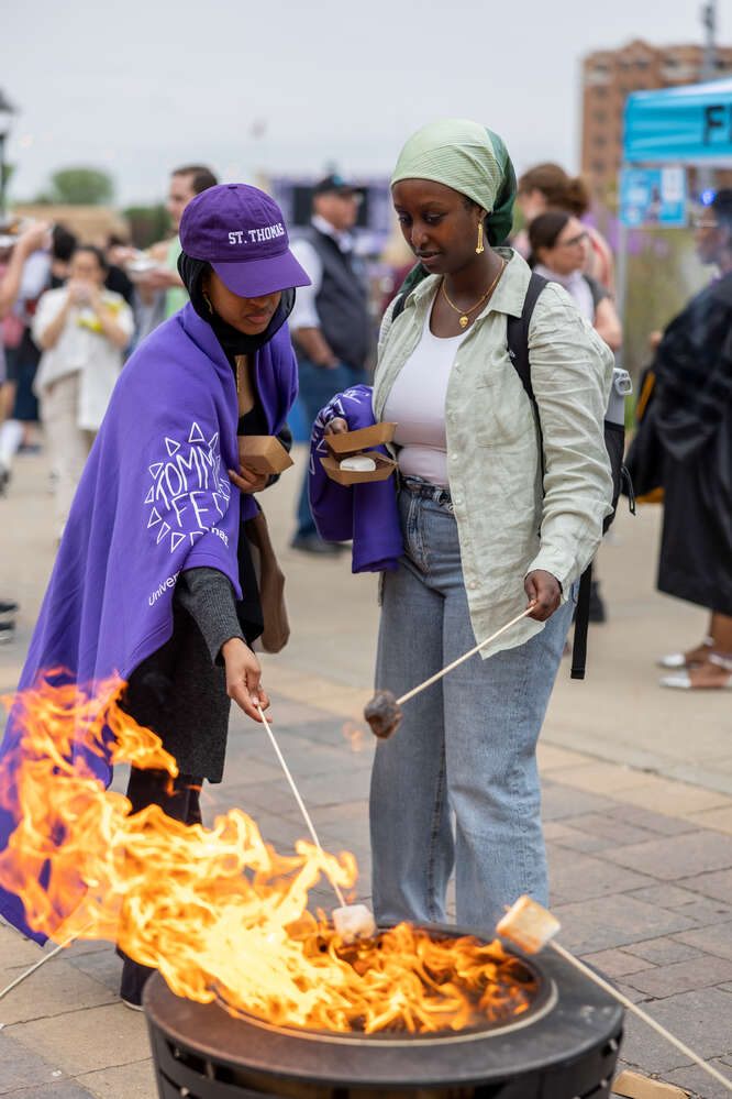Students roasting marshmallows for s’mores during Tommie Fest in St. Paul on May 12, 2023.