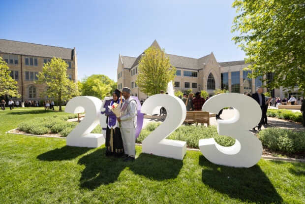 Family celebrate and take photos on the quad in front of a 2023 letters after the College of Arts and Sciences Commencement Ceremony in the AARC Field House on May 20, 2023, in St. Paul.