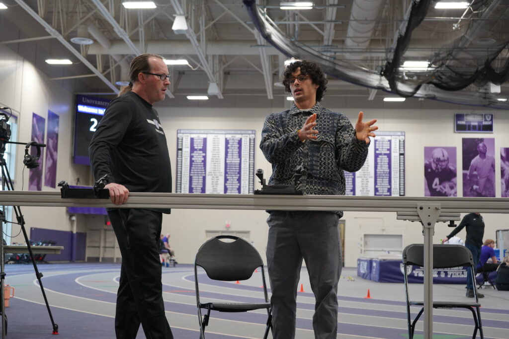 Ezra Wells shows off the new laser measuring system at the University of St. Thomas Track and Field indoor meet on Jan. 12.