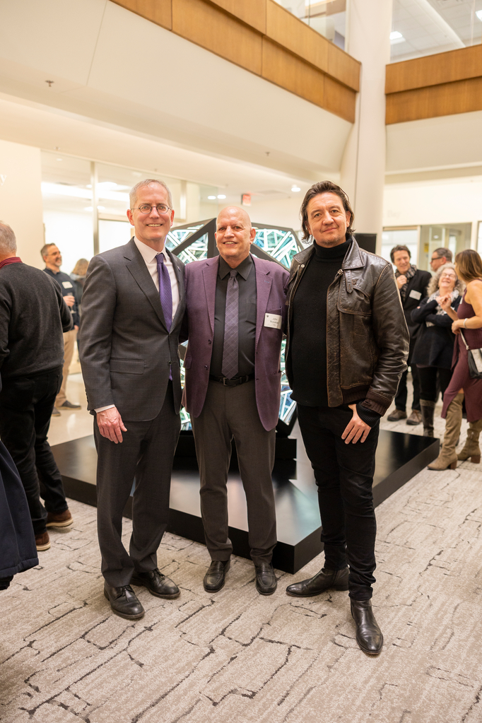 President Vischer, John P. Monahan, and Anthony James pose for a photo in front of the Portal Icosahedron at the Monahan Gallery Opening and James Glass Sculpture Unveiling in the Schoenecker Center on February 15, 2024 in St. Paul