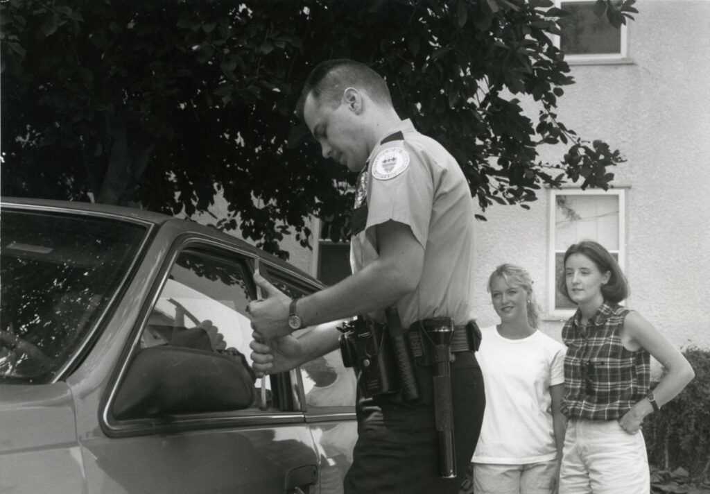 A Public Safety officer opening a locked car.