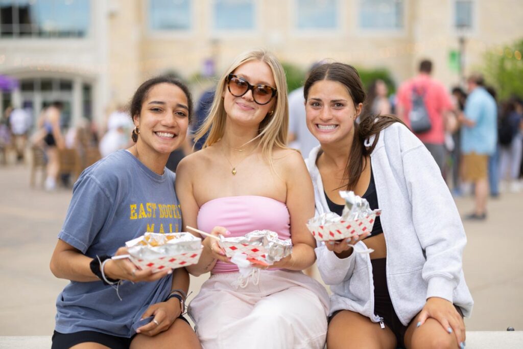 Students pose with food from food trucks