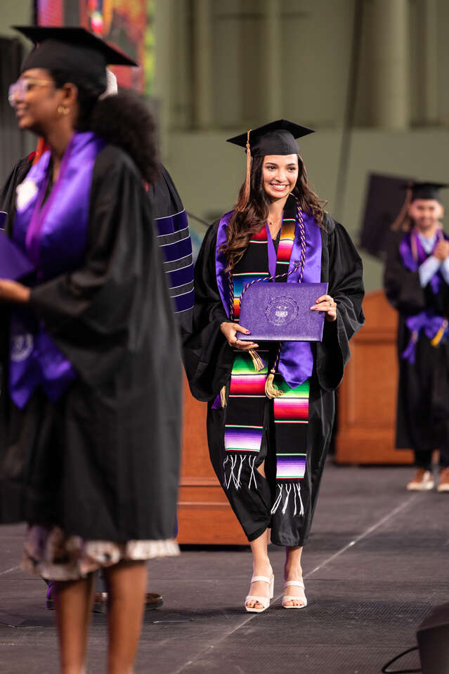 Students walk across the stage during the 2024 Opus College of Business Undergraduate Commencement Ceremony.