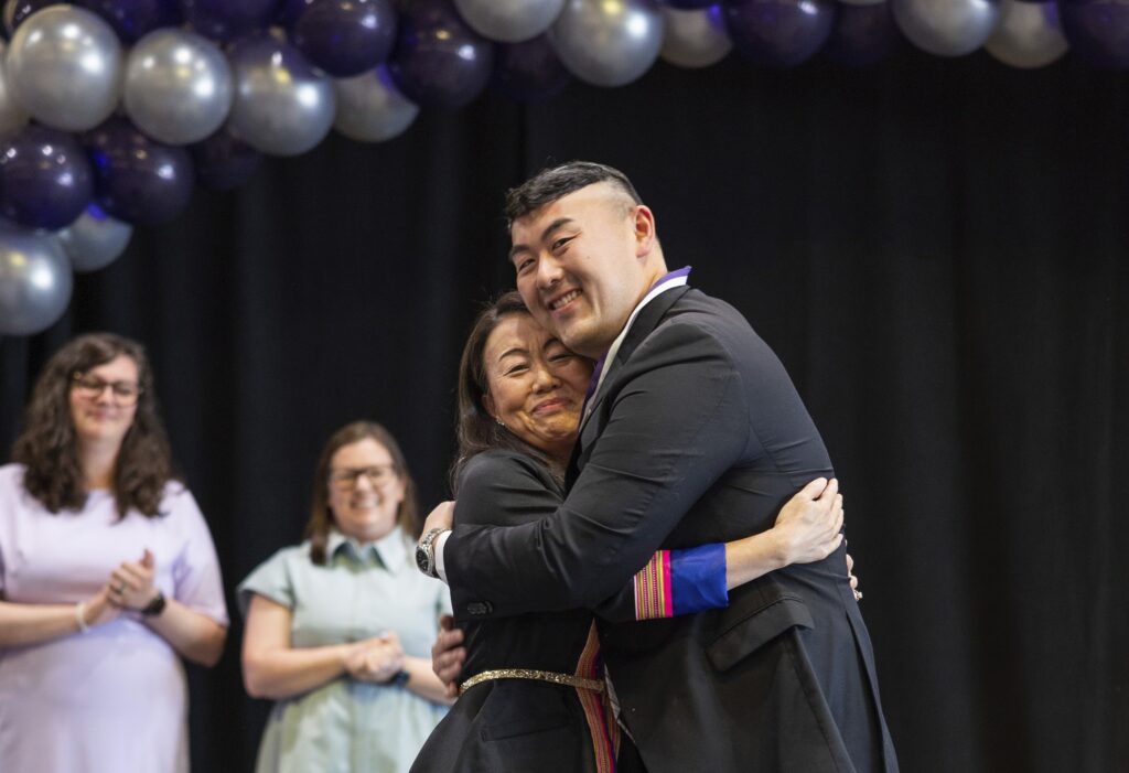 Justin Hang '24 MSN hugs his aunt during the Susan S. Morrison School of Nursing pinning ceremony. Hang plans to pursue a position as an emergency room nurse and eventually go back to school for his doctorate in nursing.
