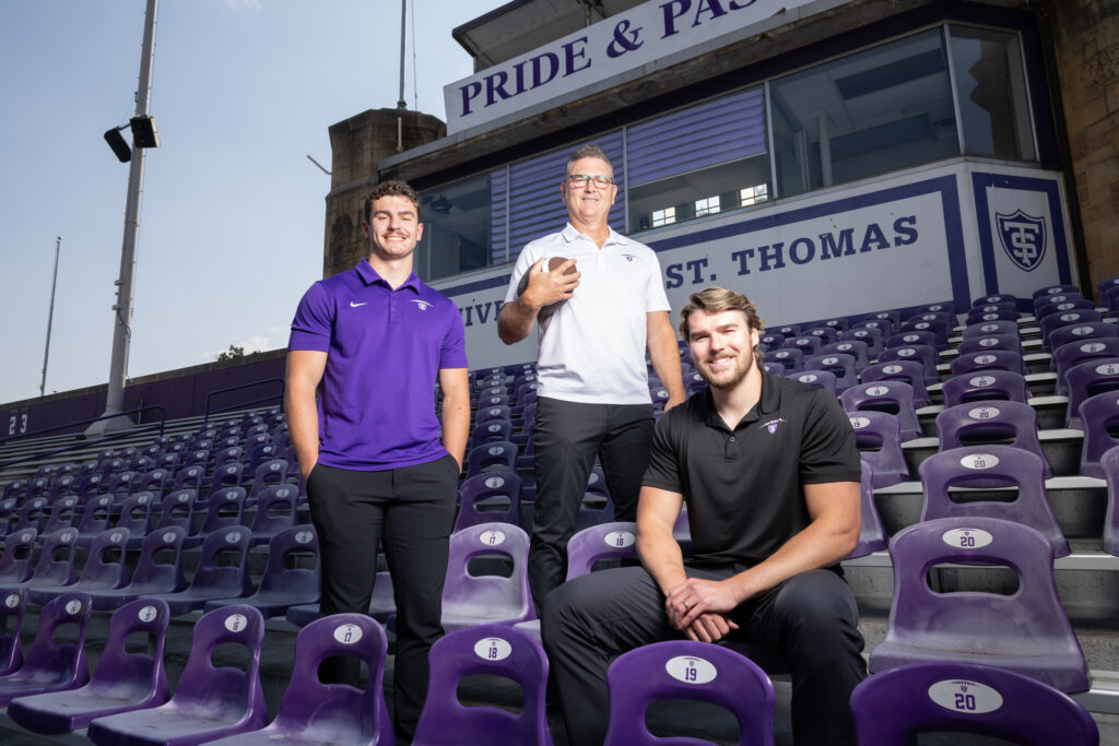 The Guggemos family, from left to right, Matt, Neal and Nick, pose for a photo in the bleachers of O’Shaughnessy Stadium.