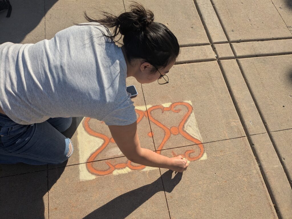 Student, Rhiannon Wilson draws with white chalk. 