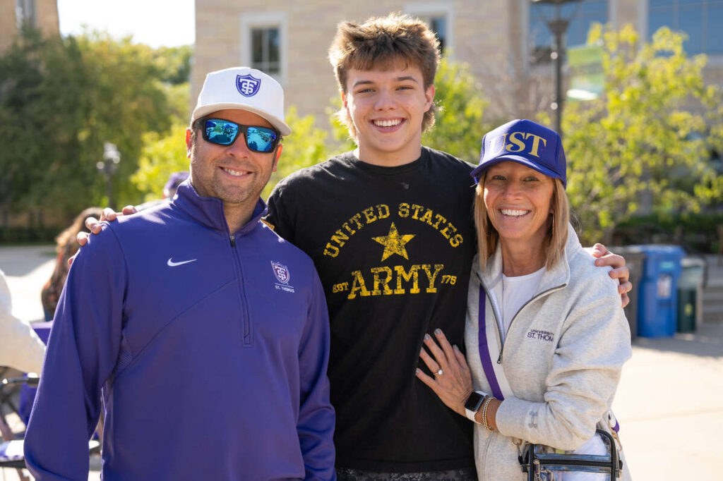 Parents pose their son.