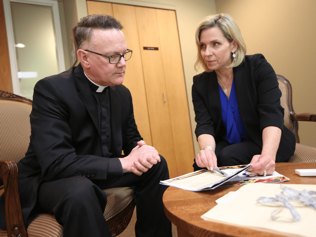 Susan Torborg with a priest.