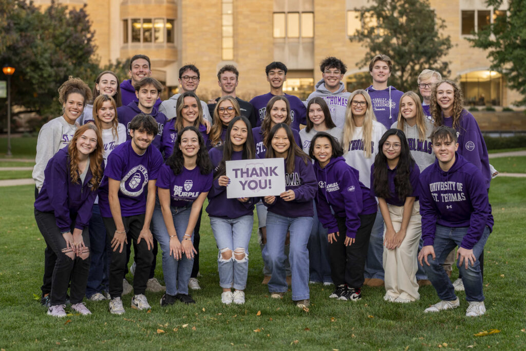 Students on quad holding thank-you sign.