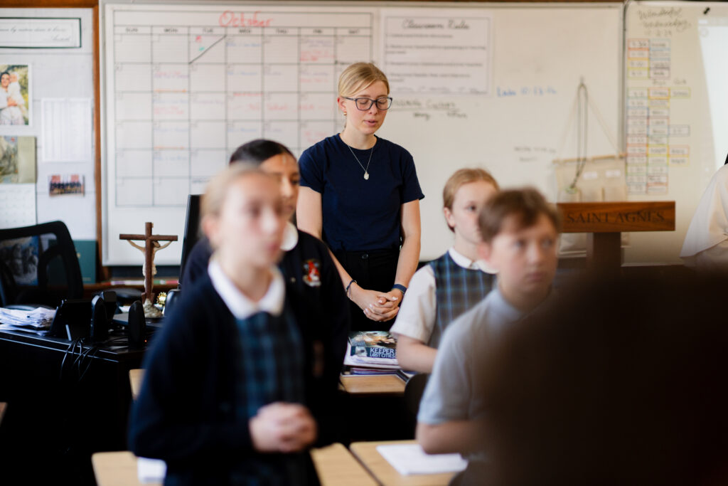 Woman praying in a classroom. 