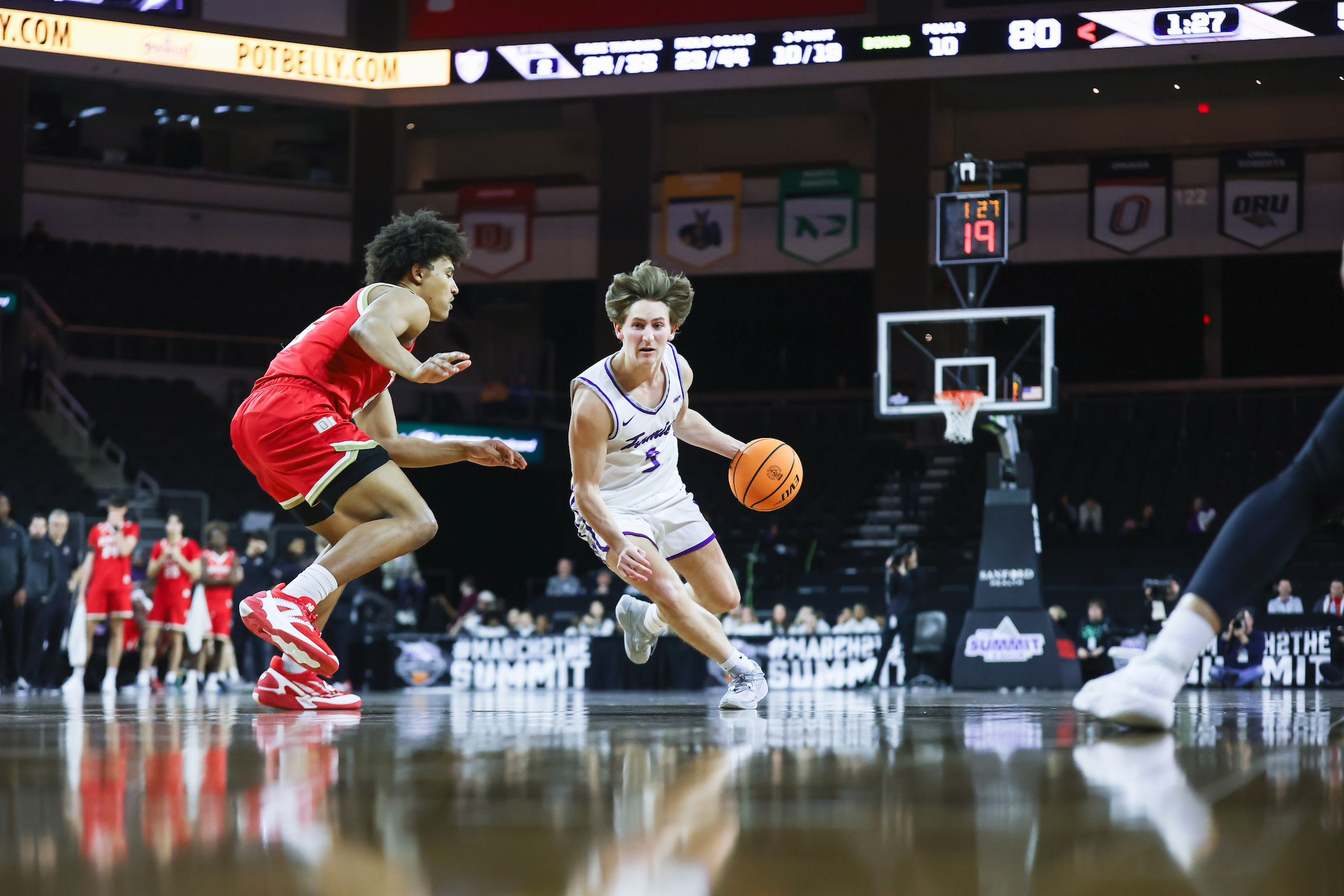 Men's basketball student-athlete Hayden Tibbits runs the ball during a game against Denver in the Summit League Championships.
