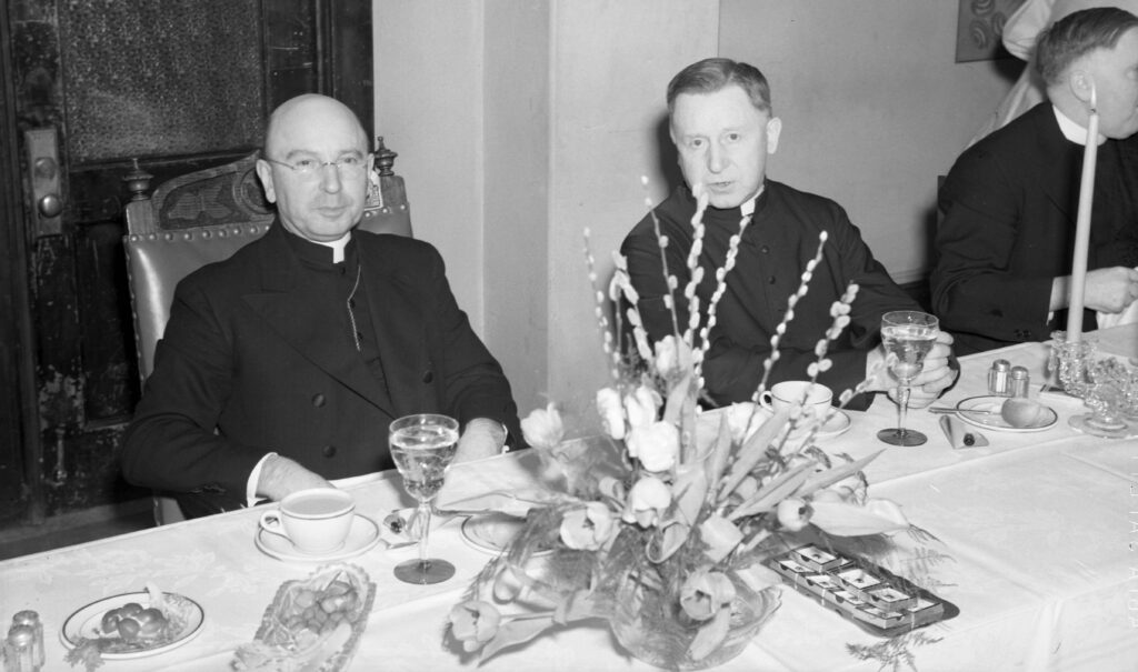 Priests sitting at a table for St. Thomas Day