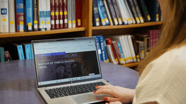 Student using laptop open to the Master of Public Health home page