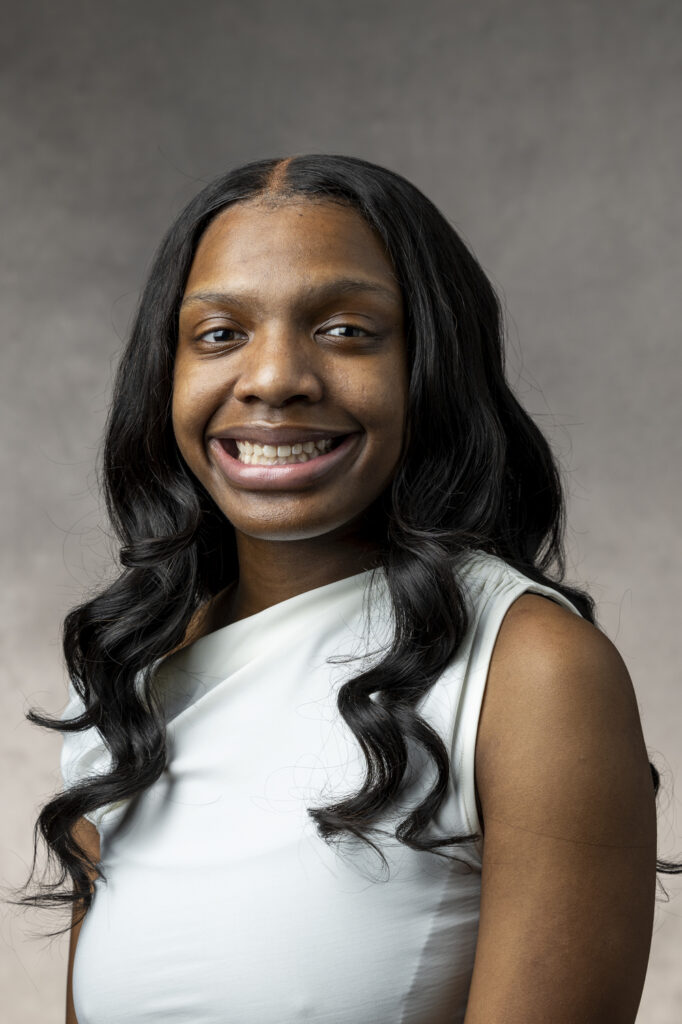 Junior Ariah Crosby smiling for headshot against grey background