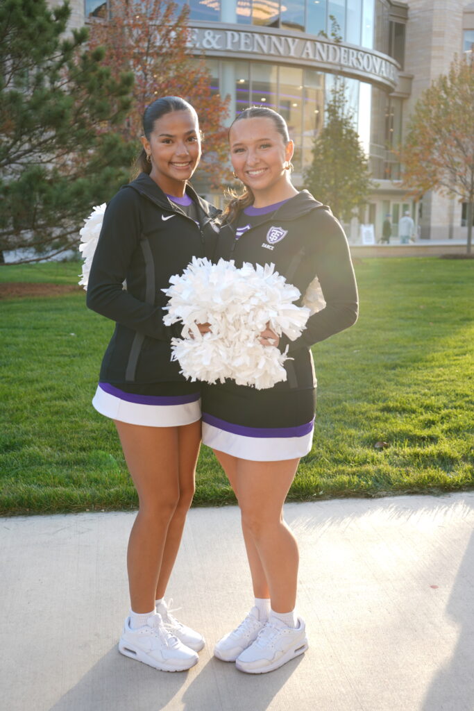 Two Tommie Spirit members photo op in front of hockey arena.