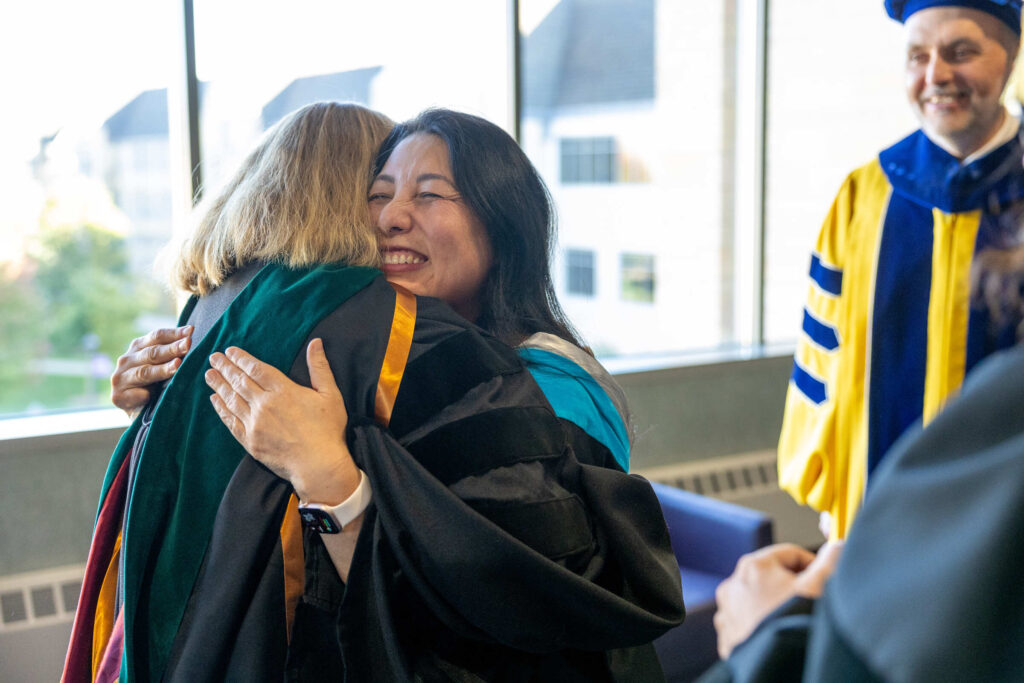 Dean MayKao Hang receives hug at investiture