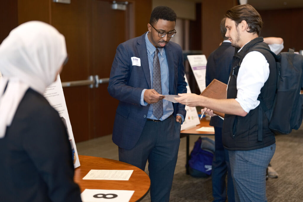 Recruiter hands student paperwork