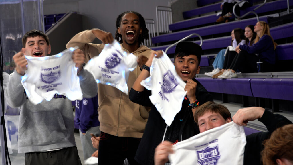 Four students hold Tommie towels