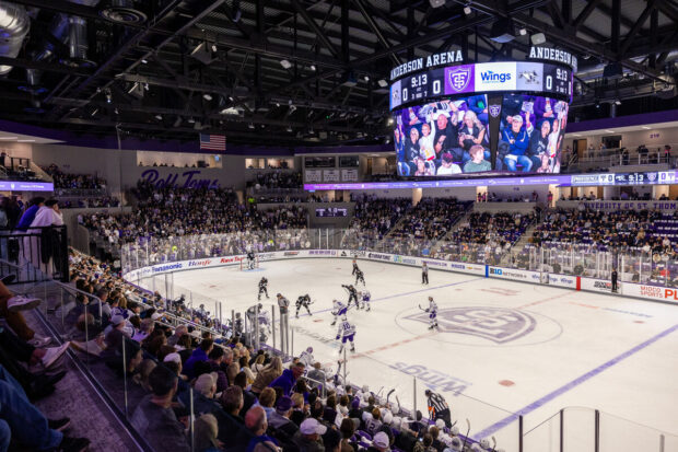 Overview of crowd and men's hockey on ice in inaugural game