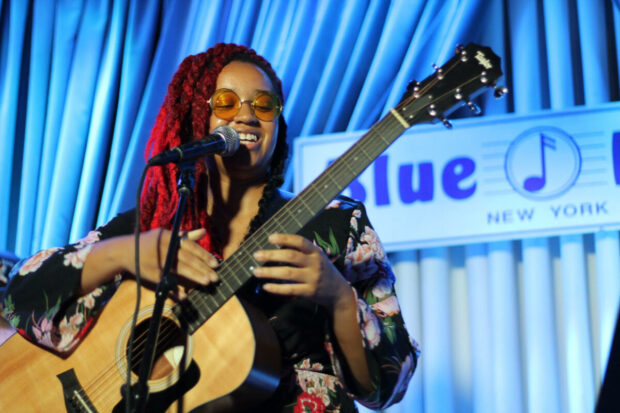 iamchelseaiam playing guitar on stage.