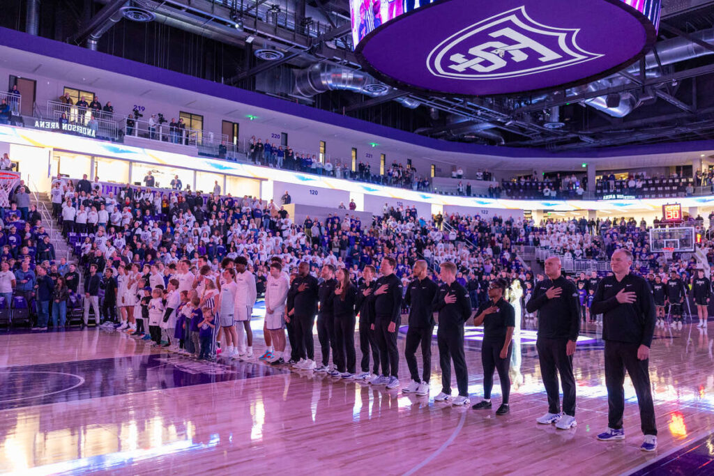 St. Thomas men's basketball lined up on the floor during the National Anthem.