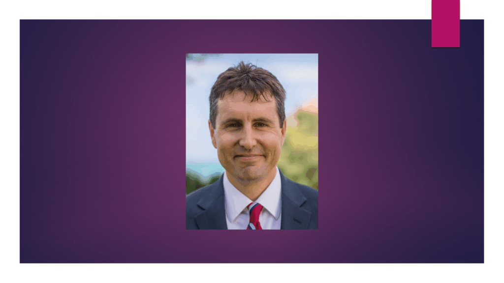 Headshot of Professor Michael Rota with a purple background.