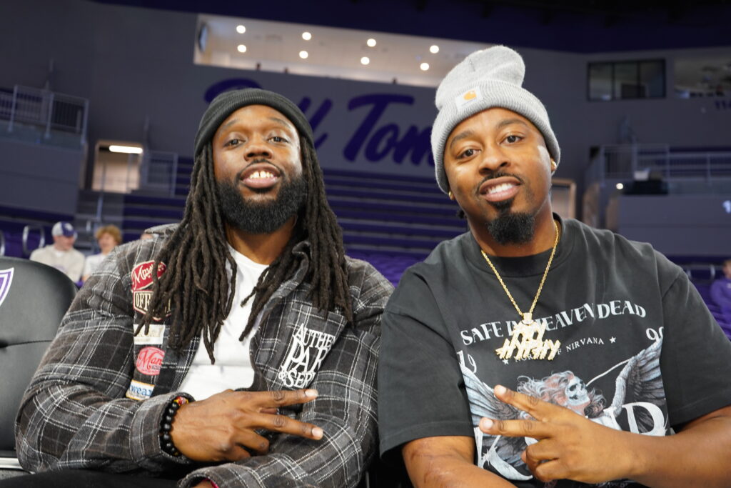Two fans sit court side