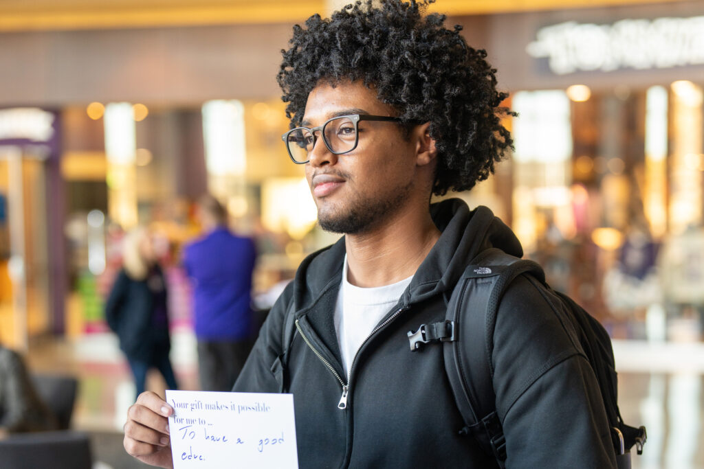 A student holds thank you card