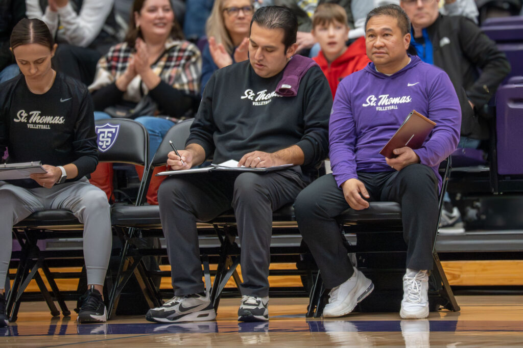 Three St. Thomas coaches sitting on the bench