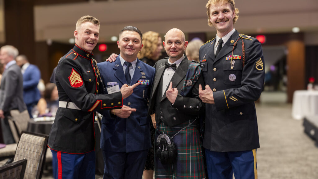 Norman Ferguson Jr. and Attendees posing for a photo at the Veterans Ball in James B. Woulfe Alumni Hall.