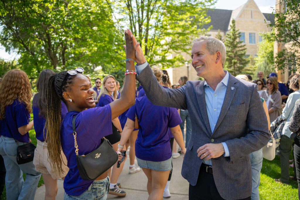 President Rob Vischer gives a student a high five during March out of the Arches on May 23, 2025, in St. Paul.