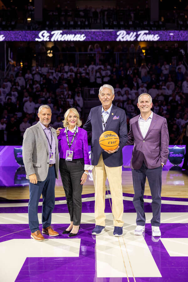 Benefactors Lee and Penny Anderson (center) join Athletics Director Phil Esten (left) and President Rob Vischer at the Men's Basketball versus Army at the Lee & Penny Anderson Arena on Nov. 8, 2025 in St. Paul.