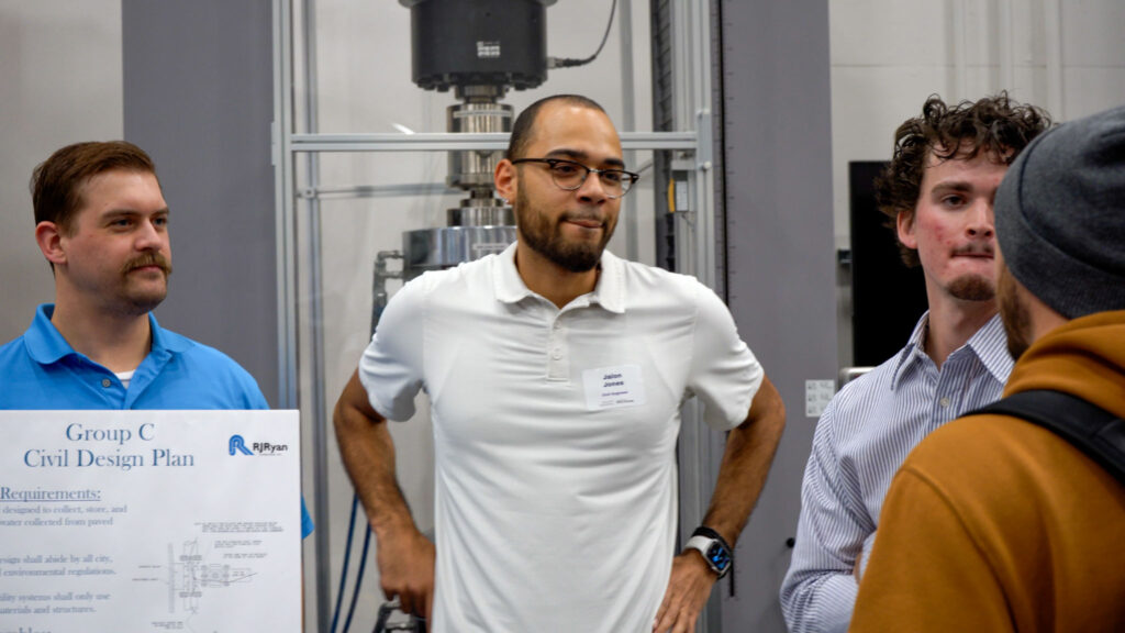 The team members listening to a visitor ask a question.