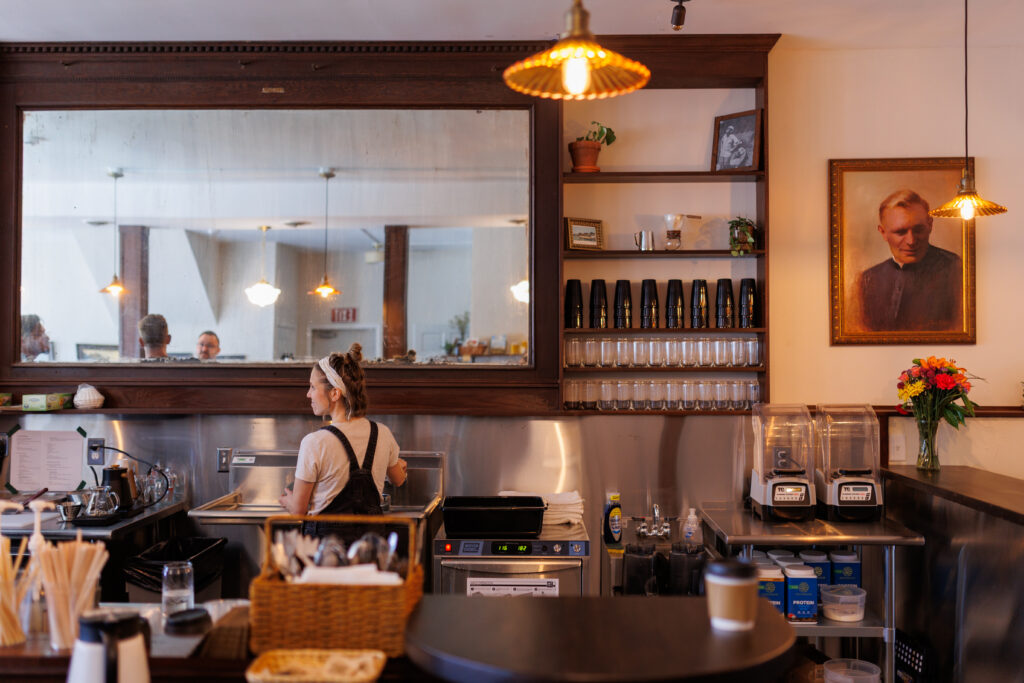 Photo of barista working at counter making coffee