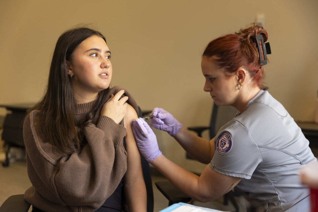 Nursing student administers shot at flu clinic