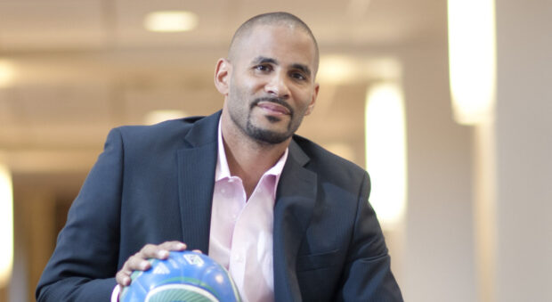 Tony Sanneh sitting with a soccer ball