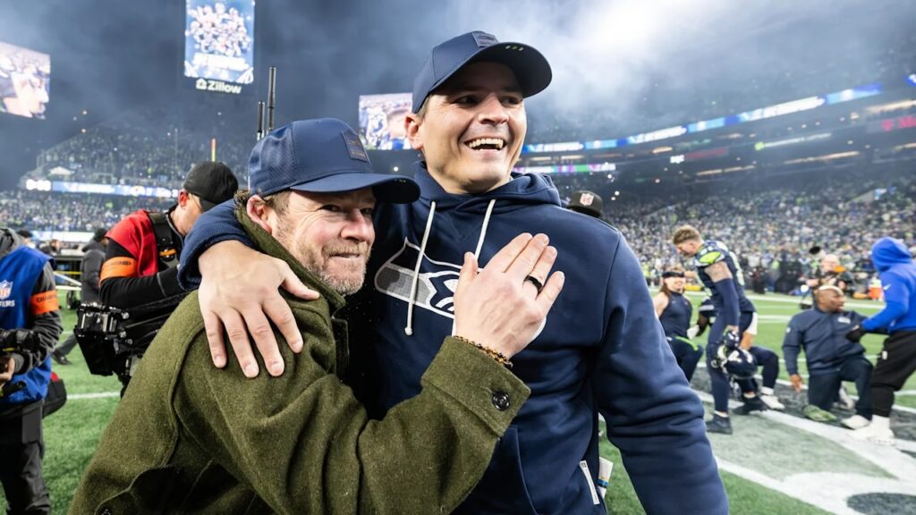 Seahawks president of football operations/general manager John Scheider hugs head coach Mike McDonald.