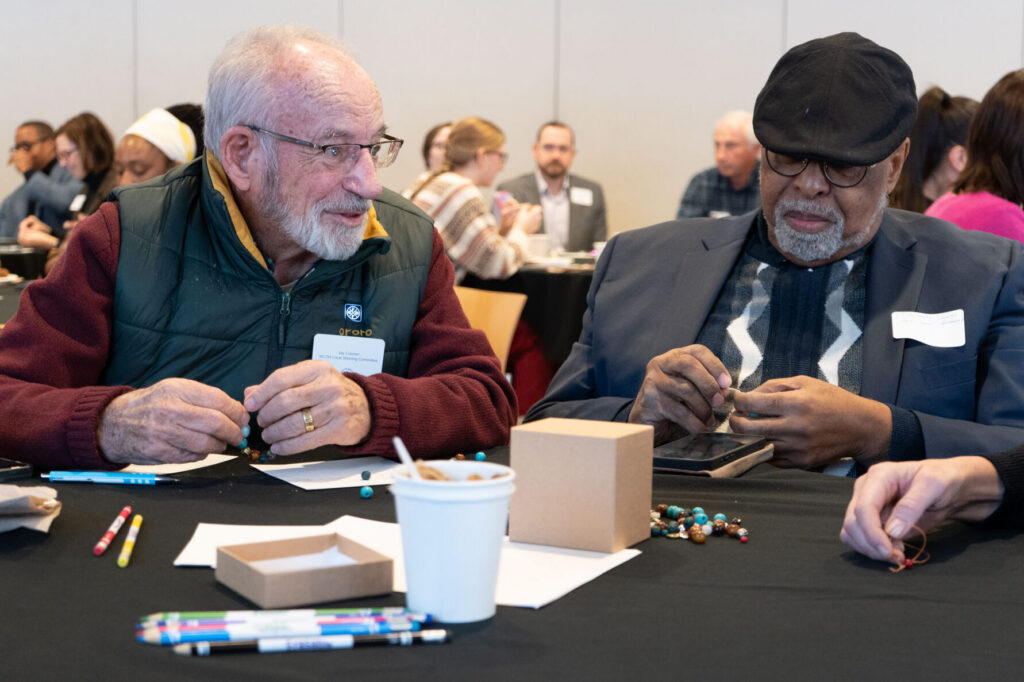 Guest engage in narrative storytelling exercise with breaded bracelets.