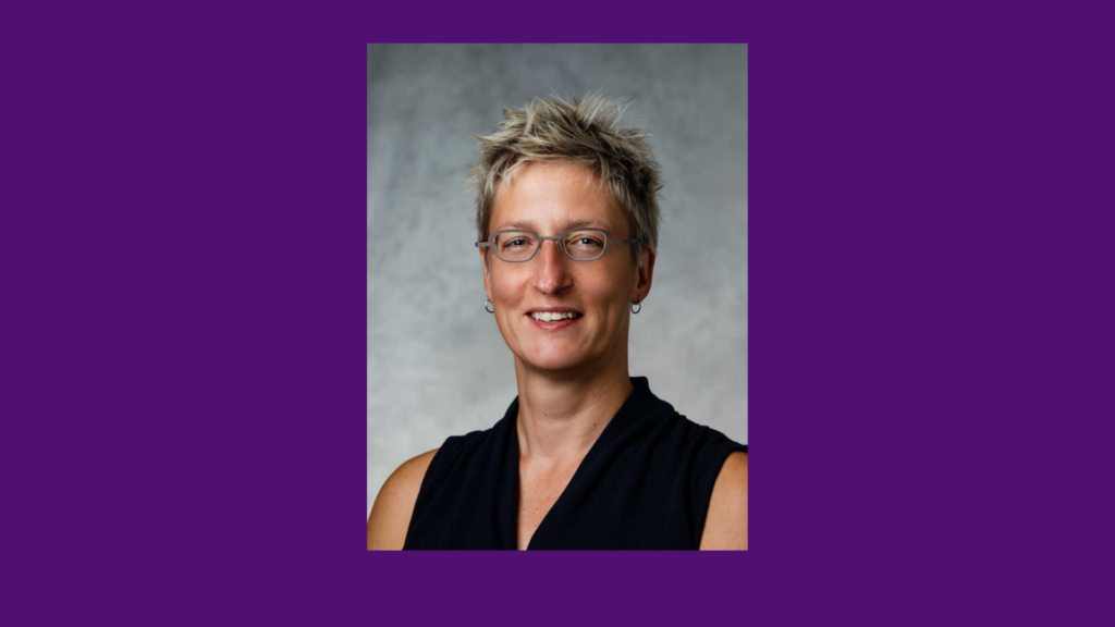 A woman smiles for a professional studio portrait.