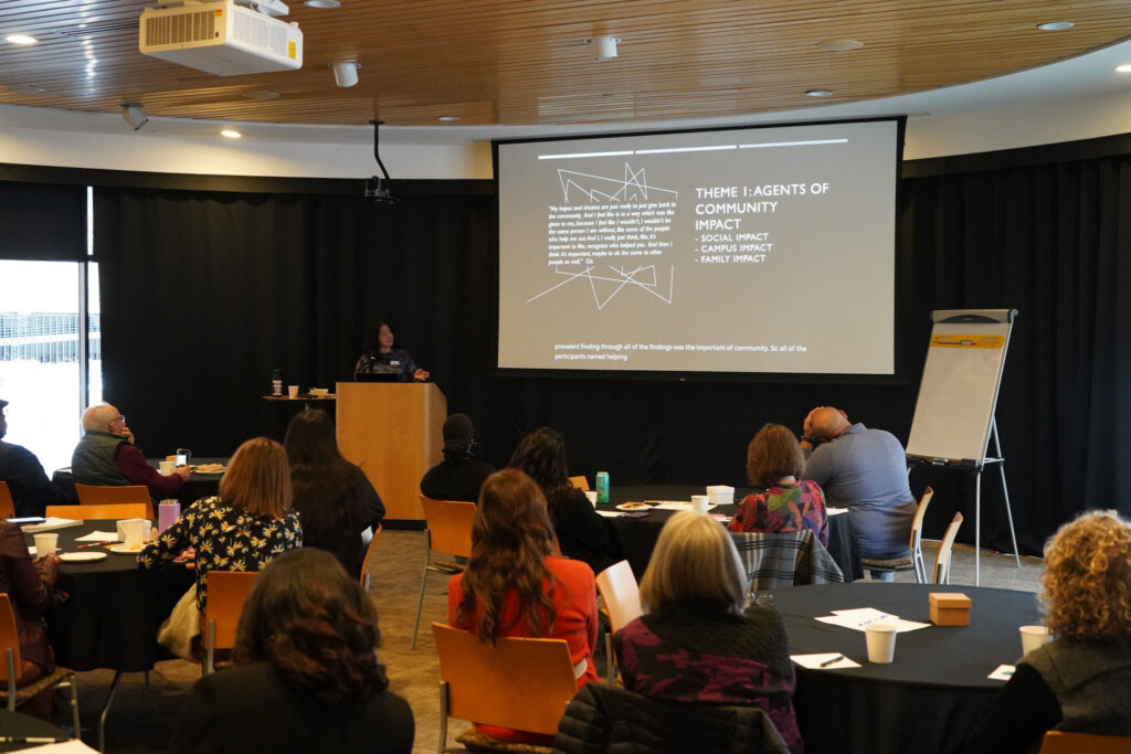Katia Colón-LaCroix speaks at podium with a powerpoint presentation.