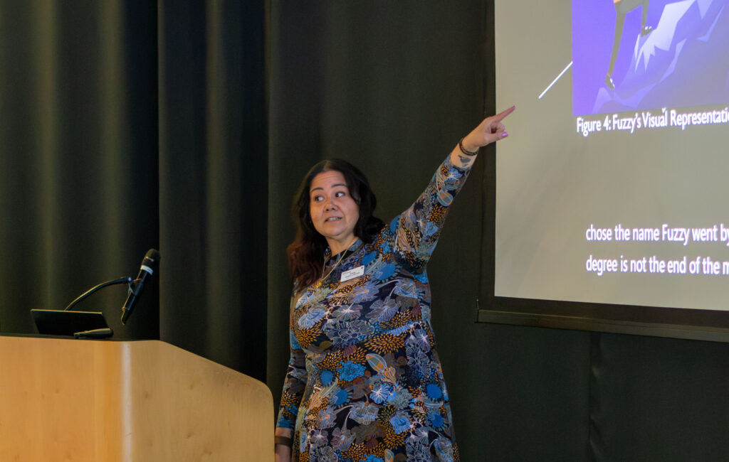 Katia Colón-LaCroix pointing at a slideshow presentation.